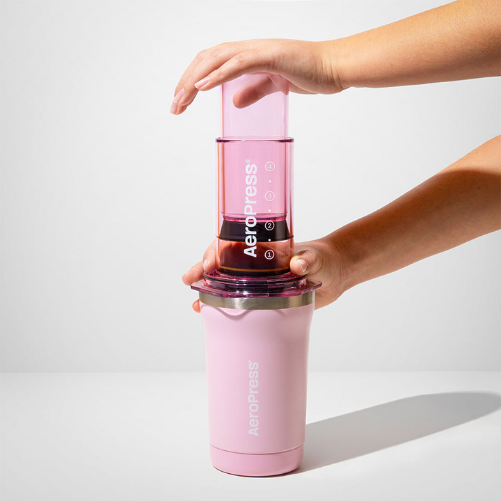 AeroPress Go Plus Travel System - Pink, pendant le pressage à deux mains - Coffee Coaching Club