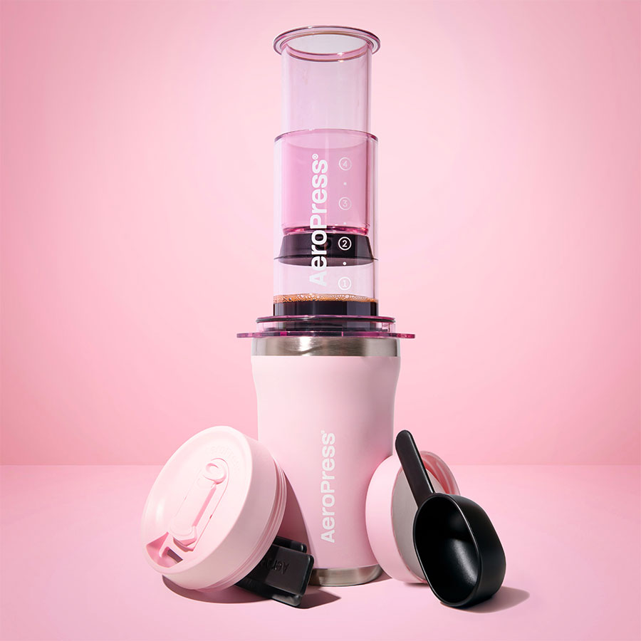 AeroPress Go Plus Travel System - Pink, photo studio avec gobelet, couvercles et cuillère doseuse - Coffee Coaching Club